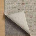 rug corner lifted to reveal underside and gray non-slip rug pad beneath it