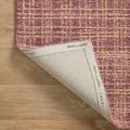 Rug corner flipped showing natural cotton backing branded with Chris Loves Julia x Loloi logos.
