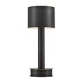 Traverse lamp providing warm light from under metal shade in dimly lit setting