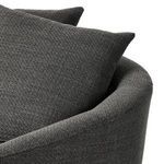 Angled front view featuring round silhouette and soft throw pillows inside armrests