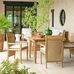 Outdoor dining area with several Savannah Teak Arm Chairs surrounding teak table, bright patio scene