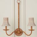 Double arm wall sconce installation with whitewashed woven seagrass shades against a white paneled wall