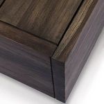 Tight close-up of the corner of the teak table highlighting the joint and wood texture