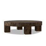 Round coffee table angled to show three squared legs and thick veneer top with natural wood texture