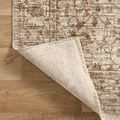 Rug corner flipped up revealing underside weave and fringe on hardwood