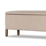 Detailed corner view of trunk’s upholstery meeting rounded wood legs with smooth grain