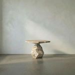 Sculptural end table with faceted geometric base and hexagonal top in textured beige marble