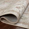Rolled edge of rug displaying thin pile height and texture of power-loomed polyester