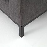 Close-up detail of black iron base leg with sharp corner stitching on fabric