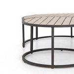Close-up side angle showing aluminum frame legs and circular base of larger table
