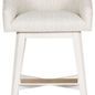 Front view of Ryder stool with gold-tone footrest bar contrasting white wood base and light fabric upholstery