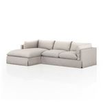 Neutral slipcovered 2-piece sectional with left-facing chaise, pillow cushions, and shelter-style arms