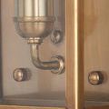 Close-up of sconce backplate showing brushed brass tone with screws and mounting points