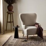 Close-up back corner of chair’s wingback and smooth linen upholstery