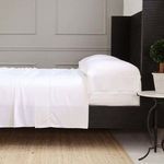 California King Sheena Bamboo Sateen Sheet Set in white on black platform bed with pillows, side table and plant