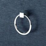 Close-up of round polished metal ring pull on bottom drawer of the side table