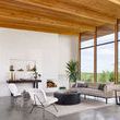 Living room with large windows featuring sofa and chairs, no table visible