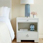 Frances side table in bedroom setting with blue lamp and decorative geometric box on open shelf