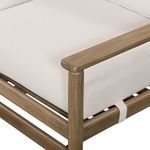 close-up of corner showing cushioned seat with fabric straps securing cushions
