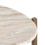 Detailed close-up of oval taupe marble tabletop edge with brass frame corner