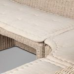 Close-up of tufted cushion edges resting on rattan frame with detailed weave
