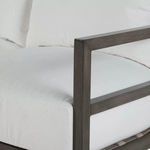 Close-up of armrest corner showing matte slate gray aluminum frame and white cushion edge