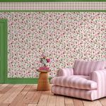 Wallpaper applied on full wall in room with green door trim, wooden floor, pink striped cushioned armchair