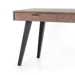 Close-up of two front drawers and angled black metal legs of the desk