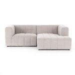 Living room setting featuring sectional with off-white walls and blue accent wall behind window seat