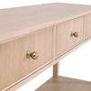 Close-up of three fluted drawer fronts with round metallic knobs