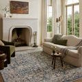 Clarisse Blue Beige Rug styled in living room setting with sofa, armchair, and fireplace