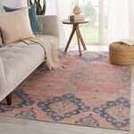 Rug laid out in bright living room with pouf, window light, and beige tufted sofa with throw blanket