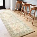 Rosette beige rug runner placed under wooden bar stools on light wood flooring