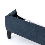 Close-up on bottom corner showing fabric wrapped bed frame and black wood leg