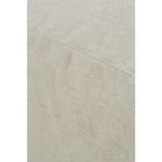 Side close-up shot focused on fabric texture and upholstery seam of ottoman slipcover