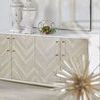 Sideboard styled in a room with decorative objects on top, herringbone door pattern visible