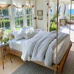 Sunlit bedroom with Blake duvet and light gray throw blanket on a hanging wooden bed frame