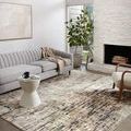 Spirit Stone Blue Rug styled in modern living room with gray sofa, wood chair, fireplace, and abundant natural light