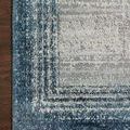 Close-up of rug corner on dark wood floor showing detailed weave and color variation