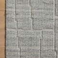 Macro detail of Asha Sky Rug's raised geometric pattern and mixed looped yarns on wood floor