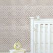 Wallpaper applied behind white crib and small stool with books and yellow clock in cozy nursery setting