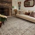 Rug featured in cozy space with cream sofa, brick fireplace, and floral accent pillow