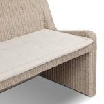 Close-up of fabric seat cushion tufting and rattan frame corner connection