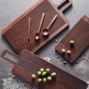 Top view of three Yami Brown bread boards with wooden utensils and green olives scattered on them
