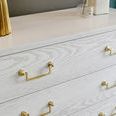 Close-up of gold detailed drawer handles and whitewashed oak textured drawer fronts on chest