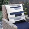 Outdoor setting showing Coronado Dining Chair with navy cushion and geometric patterned pillow