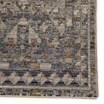 Close-up of rug corner highlighting intricate geometric border and distressed texture