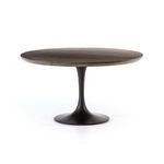 Side angle showing tulip cast-iron base and round oak tabletop with visible grain