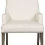 Dining arm chair upholstered in off-white Kidders Porcelain fabric with porcelain-colored leather trim and dark wood legs