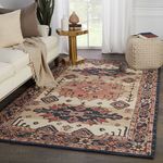 Rug styled in living room with white sofa, gold side table, cream knitted pouf, and large window